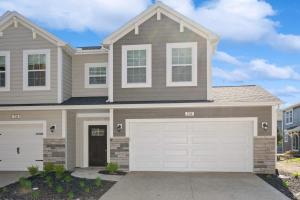 a house with white garage doors in a driveway at Sandy Shores in South Haven