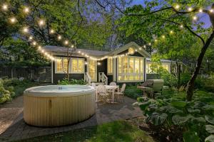 a backyard with a hot tub and a house with lights at Leo Cottage by Juniper Holiday + Home in Union Pier