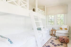 a bedroom with a bunk bed and a chair at Leo Cottage by Juniper Holiday + Home in Union Pier +37 photos