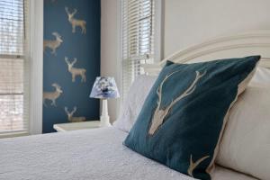 a bedroom with a bed with a blue wall at Deer Haus by Juniper Holiday + Home in New Buffalo