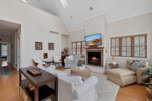 a living room with white furniture and a fireplace at Deer Haus by Juniper Holiday + Home in New Buffalo