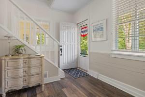 a hallway with a white door and a wooden dresser at Whispering Arbor by Juniper Holiday + Home in Lakeside