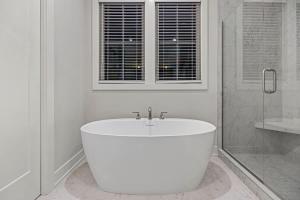 a white bathroom with a tub and a shower at The Happy Place by Juniper Holiday + Home in Union Pier