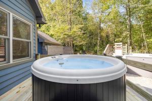 a hot tub on a deck next to a house at Blue Beech Cottage in Union Pier