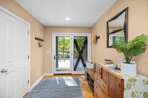 a home hallway with a wooden dresser and a mirror at Blue Beech Cottage in Union Pier +29 photos