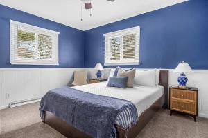 a blue bedroom with a bed and two windows at Golden Crest Getaway in Stevensville