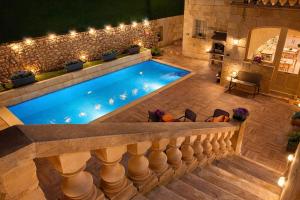 an infinity pool with a stone wall and lights at Ta' Matmura Boutique B&B in Għarb