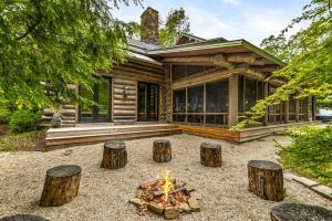a log house with a fire pit in front of it at Wilder Woods in Michiana