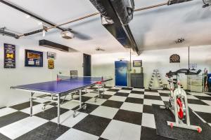 a room with a ping pong table on a checkered floor at Hearth & Timber in Bridgman