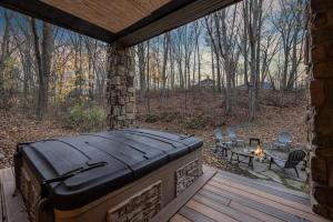 a patio with a hot tub and a fire pit at Lodged in the Trees in New Buffalo