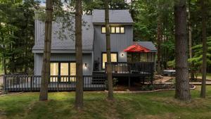 a house with a porch in the middle of trees at La Maison du Lac in Sawyer