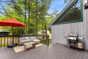 a patio with a bench and a grill and an umbrella at La Maison du Lac in Sawyer +30 photos