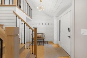 a hallway with white walls and a staircase with a chair at Loma House in Sawyer +51 photos