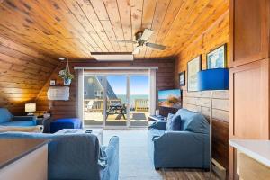 a living room with blue chairs and a ceiling at Leilas Chalet in Stevensville