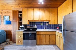 a kitchen with wooden cabinets and a stainless steel refrigerator at Leilas Chalet in Stevensville