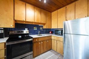 a kitchen with wooden cabinets and a stainless steel refrigerator at Leilas Chalet in Stevensville +41 photos