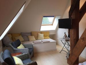a living room with a couch and a tv at B&B Idylle aan Zee incl 2 Wellnessstudios in Sint Maartensvlotbrug
