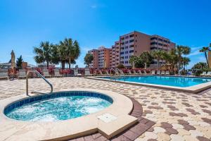 a hot tub in a patio next to a building at Condo in oceanfront complex with pools private beach access and balcony in Destin