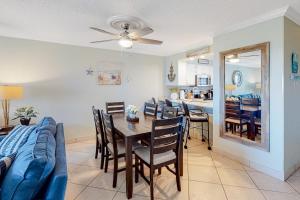 a dining room and living room with a table and a couch at Condo in oceanfront complex with pools private beach access and balcony in Destin