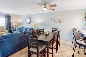 a living room with a blue couch and a table at Condo in oceanfront complex with pools private beach access and balcony in Destin +19 photos