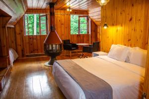 a bedroom with a bed in a wooden cabin at ARAÝ Pousada in Campos do Jordão