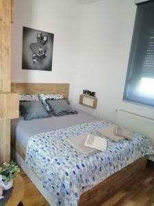 a bedroom with a bed with a blue comforter at Orca Apartman in Jagodina