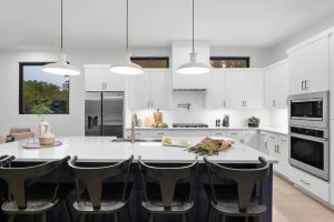 a white kitchen with a large white table and chairs at Stylish Southern Home with Heated Pool in Austin