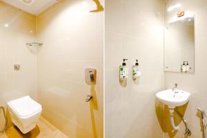 a bathroom with a shower and a toilet and a sink at Hotel Indore Palace Nagpada in Mumbai