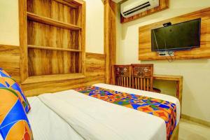 a room with a bed and a flat screen tv at Hotel Indore Palace Nagpada in Mumbai