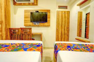 a living room with two beds and a tv at Hotel Indore Palace Nagpada in Mumbai +55 photos