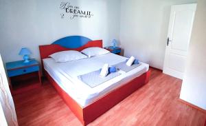 a bedroom with a red and white bed with two tables at Apartmani Marijana in Bol