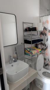 ein Badezimmer mit einem weißen Waschbecken und einer Toilette in der Unterkunft Itatia1 in Playa del Carmen + 1 Foto