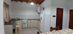 a kitchen with a white refrigerator and a stove at Cabañas Termales in Termas de Río Hondo