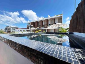 a swimming pool in front of a building at BORÉNA Hotel Boutique in Playa del Carmen