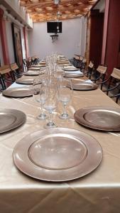 a long table with plates and wine glasses on it at Hotel Raices in Ambato