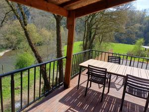 a wooden deck with a table and chairs on it at Vue sur Ourthe in Durbuy