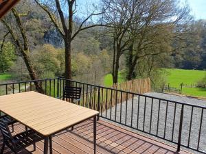 a wooden table and chairs on a balcony at Vue sur Ourthe in Durbuy +4 photos