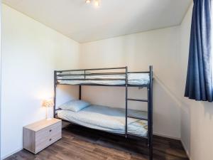 a bedroom with a bunk bed and a night stand at Sluisje 15 in Kuinre