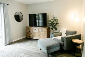 a living room with a chair and a tv at Perfect Small Family Beach Condo in Saint Simons Island