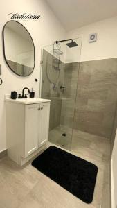 a bathroom with a shower with a sink and a mirror at Habitara - Carancho in Atasta de Serra