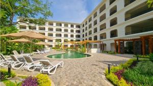 a resort with a pool and lounge chairs and umbrellas at Escape to Paradise in Tangolunda
