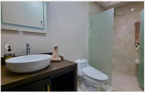 a bathroom with a white sink and a toilet at Escape to Paradise in Tangolunda +7 photos