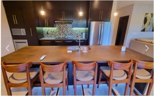 a kitchen with a large wooden table with chairs at Escape to Paradise in Tangolunda