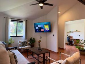 a living room with a couch and a tv on the wall at Casa a una cuadra del centro comercial in Oaxtepec