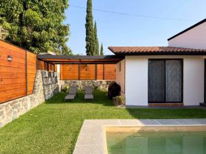 a yard with two chairs and a house at Casa a una cuadra del centro comercial in Oaxtepec