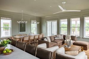 a living room with a couch and a dining room at Modern Coastal Home with Heated Pool in Bay Saint Louis