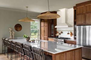 a kitchen with a large kitchen island with chairs at Modern Coastal Home with Heated Pool in Bay Saint Louis +40 photos