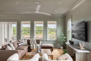a living room with a couch and chairs and windows at Modern Coastal Home with Heated Pool in Bay Saint Louis
