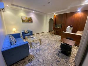 a living room with a blue couch and a table at شقق هذا منزلي المخدومة in Riyadh