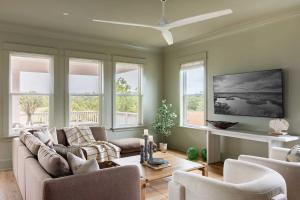 a living room with a couch and chairs and windows at Modern Coastal Home with Heated Pool in Bay Saint Louis